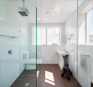 a bathroom with a glass shower and a sink at 57Hotel in Sydney