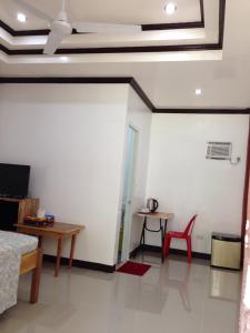 Zimmer mit einem Bett, einem Tisch und einem Stuhl in der Unterkunft Nine Clouds Homestyle Accommodation in General Luna