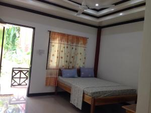 a bedroom with a bed in a room with a window at Nine Clouds Homestyle Accommodation in General Luna