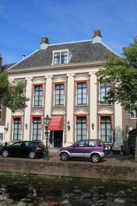 a house with two cars parked in front of it at De Doelen in Leiden