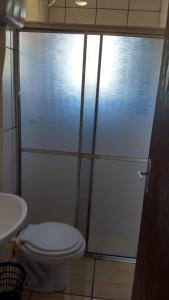 La salle de bains est pourvue d'une douche, de toilettes et d'un lavabo. dans l'établissement Pousada vila oeste, à Itapoá