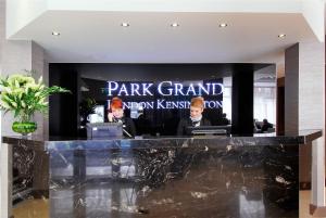 a park grand lobby with two men sitting at a counter at Park Grand London Kensington in London