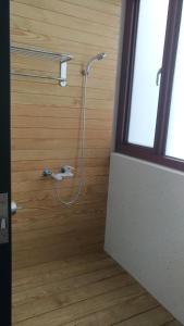 a shower with a hose attached to a wooden wall at Tropical Fish B&B in Magong