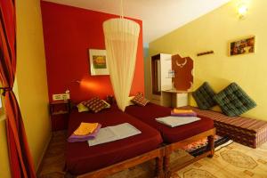 un soggiorno con letto rosso e specchio di Namaste Yoga Farm a Gokarna
