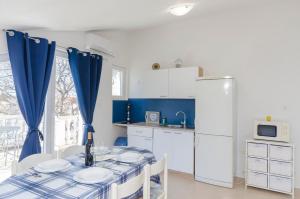 a kitchen with a table and a refrigerator at Apartments Snjezana in Pirovac