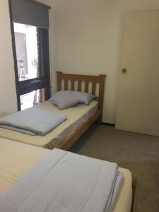 2 camas en una habitación pequeña con ventana en 6677, en Glen Waverley