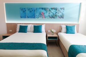 長灘島的住宿－帕緹歐太平洋度假村，两张位于酒店客房的床,配有蓝色枕头