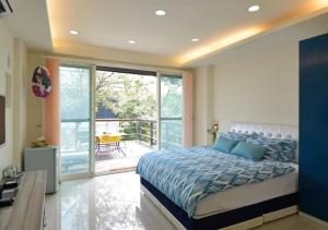um quarto com uma cama grande e uma varanda em Sanyi Wei Wei Feng B&B em Sanyi