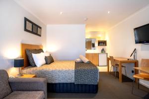 a hotel room with a bed and a living room at Tea House Motor Inn in Bendigo