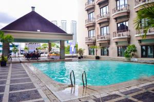 a swimming pool in front of a building at Mega Anggrek Hotel Jakarta Slipi in Jakarta