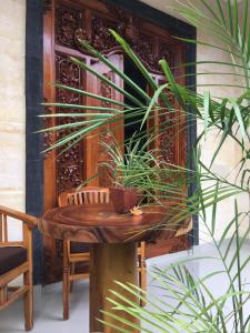 einem Holztisch mit einer Topfpflanze darauf in der Unterkunft Wina Ubud B&B in Ubud
