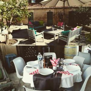 a table and chairs with plates and water bottles on it at Le Clos des Aramons in Bernis