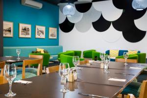 una sala da pranzo con tavoli e sedie verdi di ibis Styles Geraldton a Geraldton