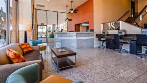 a living room with couches and a bar at Best Western Date Tree Hotel in Indio