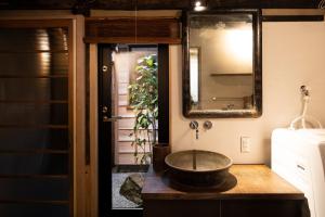 bagno con lavabo a ciotola e specchio di Kanazawa Machiya Kenroku a Kanazawa