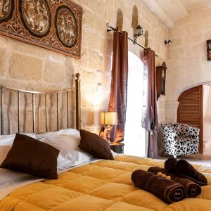 a bedroom with a large bed with two pillows on it at Mood Farmhouse Mythology in Għarb
