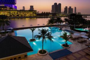 a large pool of water with palm trees at Beach Rotana - Abu Dhabi in Abu Dhabi