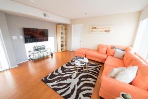 a living room with an orange couch and a zebra rug at Cozy Hollywood Get Away in Los Angeles