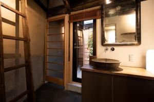 un bagno con lavandino e specchio di Kanazawa Machiya Kenroku a Kanazawa