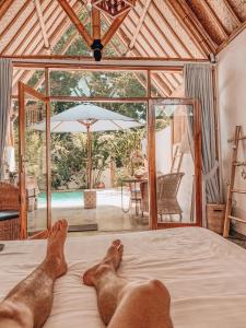 a person laying on a bed in a room at Sea Breeze Villas - Gili Air in Gili Air