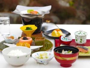 
a table topped with plates and bowls of food at Mashikokan Satoyama Resort Hotel in Mashiko
