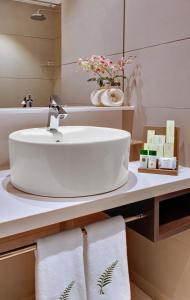 La salle de bains est pourvue d'un lavabo et d'un comptoir avec des serviettes. dans l'établissement The Fern Kesarval Hotel & Spa, Verna Plateau - Goa, à Verna