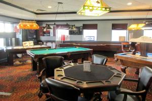 a billiard room with a pool table and several tables at Clarion Inn in Appleton