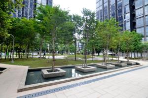 eine Reihe von Bäumen in einem Park mit Gebäuden in der Unterkunft Happy Homestay@Icon City Petaling Jaya Sunway Subang in Petaling Jaya