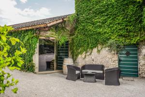 duas cadeiras e uma mesa em frente a um edifício em Weinbergsuite Panholzer em Caldaro