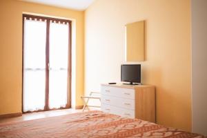 Dormitorio con cama y tocador con TV en Hotel Ristorante Mira Conero, en Porto Recanati