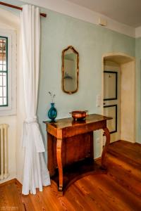 Habitación con mesa de madera y espejo. en Weinbergsuite Panholzer en Caldaro