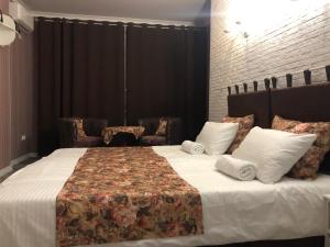 ノヴォロシースクにあるNgreyのベッドルーム1室(大型ベッド1台、白いシーツ、枕付)