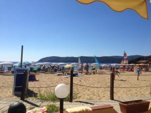 un gruppo di persone su una spiaggia con ombrelloni di Apt. Marilena by SolturElba a Capoliveri