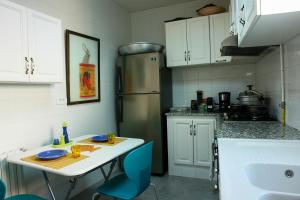 a kitchen with a table and a refrigerator at La Maison De L'artiste in Sidi Bou Saïd +13 photos