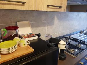 a kitchen counter with plates and cups and a stove at Casa Alessia Sanremo in Sanremo