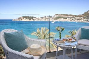 um pátio com uma mesa e cadeiras com vista para o oceano em Hotel Marina em Port de Sóller