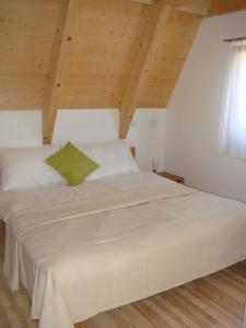 un grande letto in una camera con soffitto in legno di Ferienhäuser Finiki a Purbach am Neusiedler See