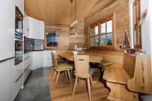 a wooden kitchen with a wooden table and chairs at Family Retreat Maria Alm in Maria Alm am Steinernen Meer