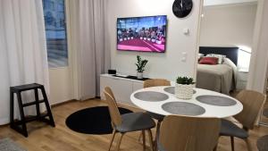 a living room with a white table and chairs at Uusi kaksio satamassa, ilmainen parkkihalli in Kuopio