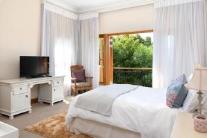 a bedroom with a bed and a tv and a window at Thomson's Accommodation in Cape Town