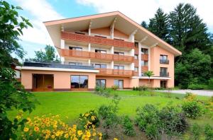 a large building with a lawn in front of it at Alpe-Adria Apartments Chanel top12 in Oberaichwald