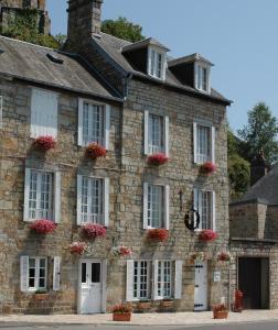 an old stone building with red flowers on it at Domfront - Numero CINQ in Domfront