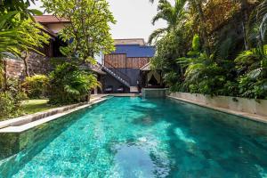 a pool in the middle of a house with blue water at Villa Yasmin in Seminyak +36 photos