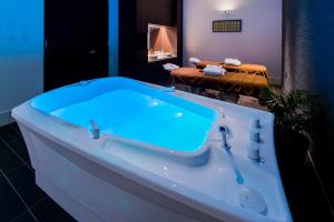 本部的住宿－オリオンホテルモトブリゾート&スパ，浴室内配有浴缸和蓝色水槽。