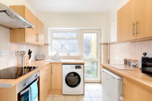 a kitchen with a washing machine and a window at Stop Looking! Walk to the City Center - TV in every Bedroom! in Swansea