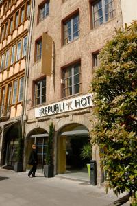 a man walking past a hospital x hot building at Republik Hotel in Lyon