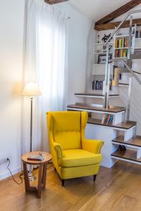 a yellow chair in a living room with a table at Loft in Venice in Venice