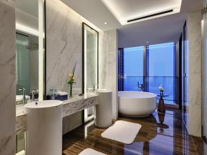 a bathroom with two sinks and a bath tub at Primus Hotel Nanchang International Expo City in Nanchang