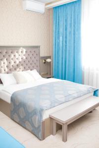 a bedroom with a large bed with a blue curtain at Old Town in Tomsk