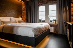 a bedroom with a large bed with a brick wall at GINN Hotel Hamburg Elbspeicher in Hamburg